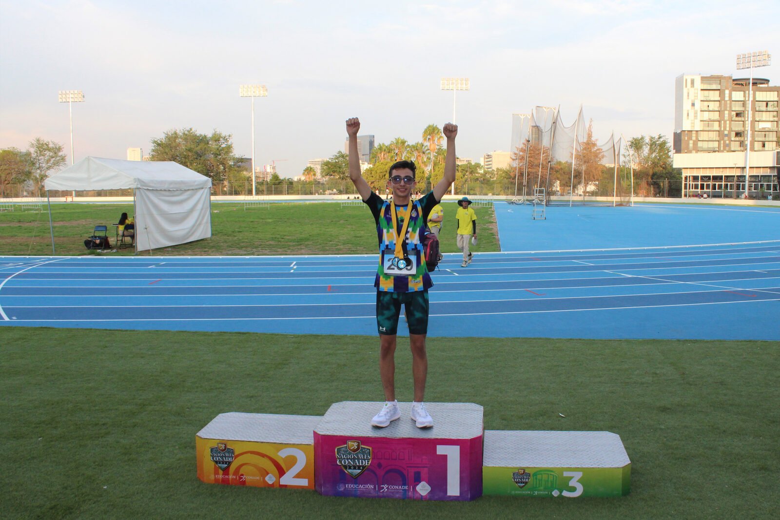 Leonardo Fernández with his arms raised on top of the podium